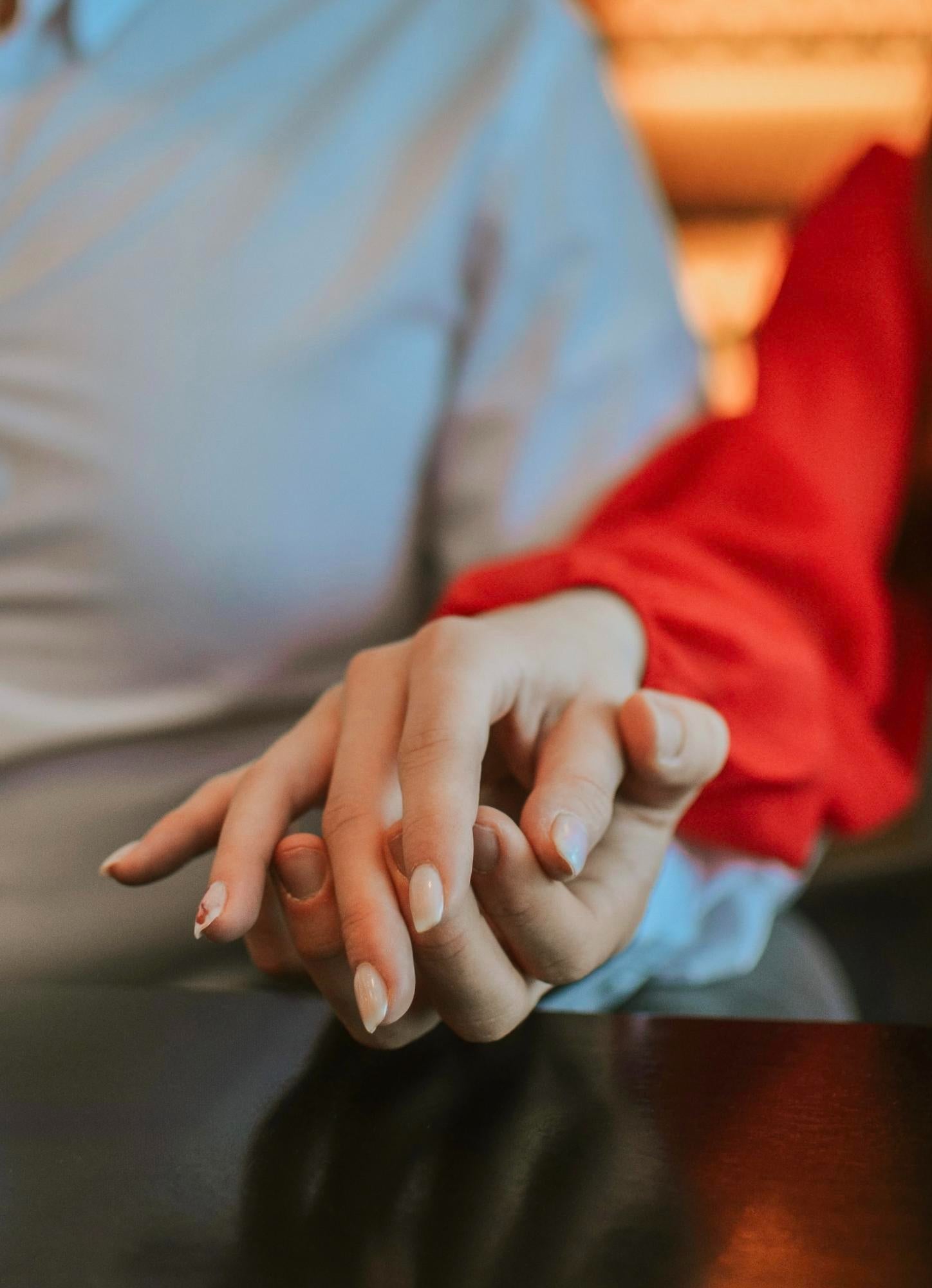Two people holding hands, showing support in Essential Tremor relationships.