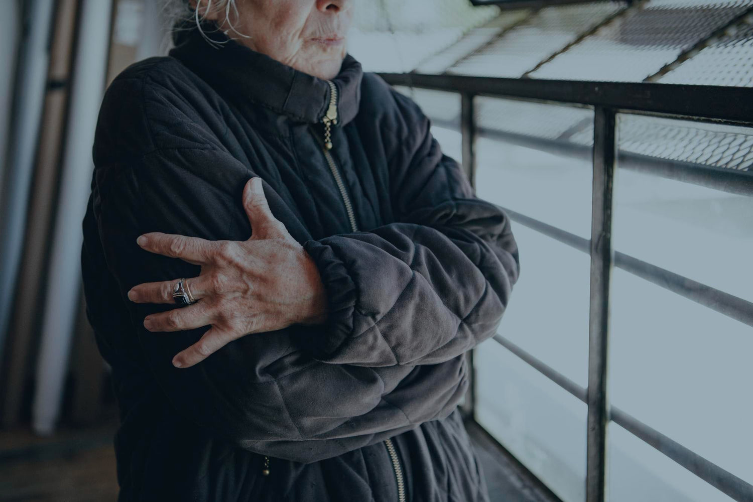 Older man with arms crossed showing subtle stiffness, one of the early warning signs of Parkinson's.