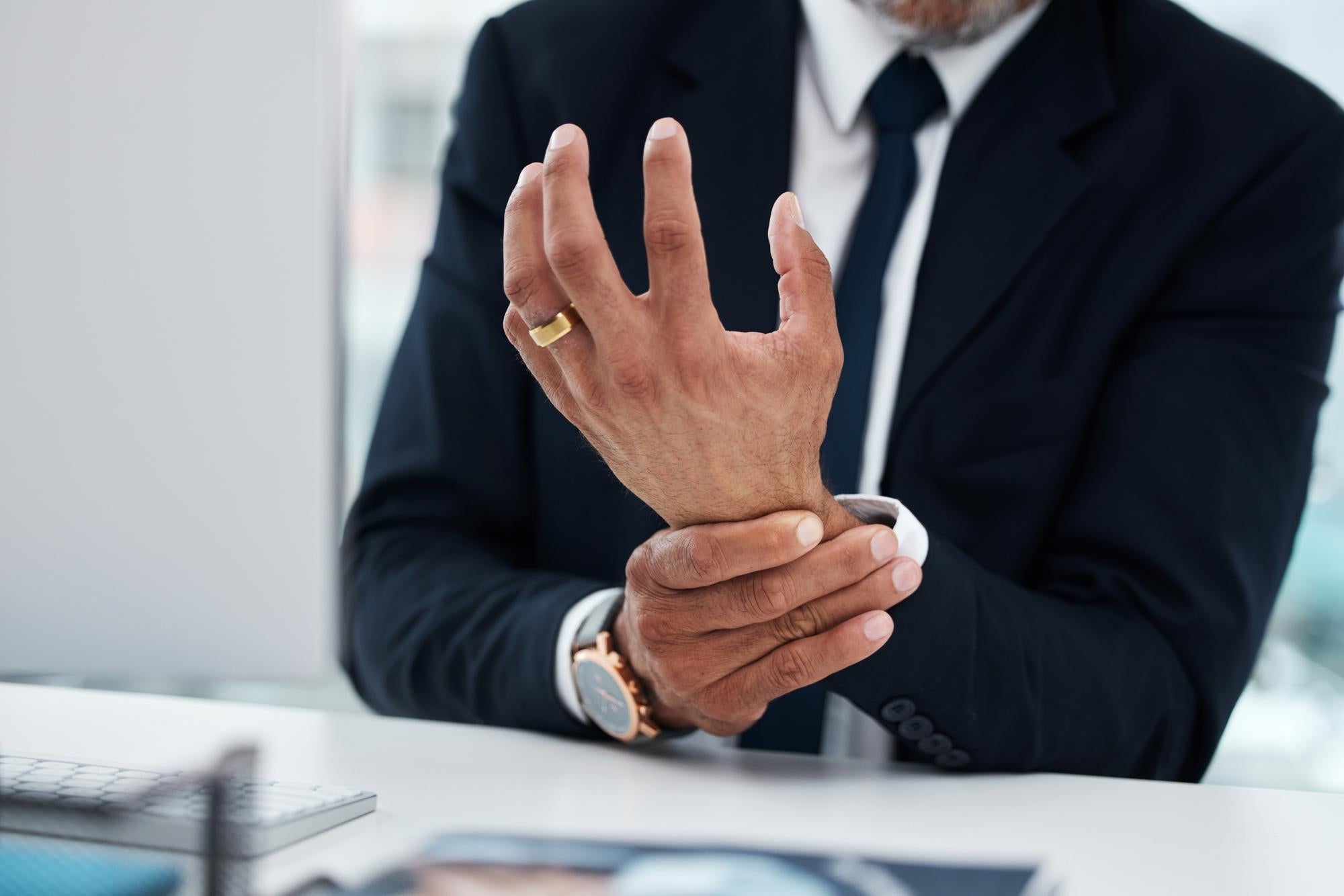 A person managing Essential Tremor at work while seated at a desk.