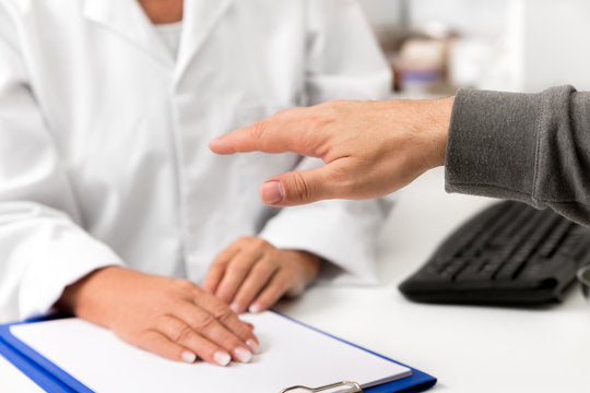 Doctor examining a patient's shaking hand.